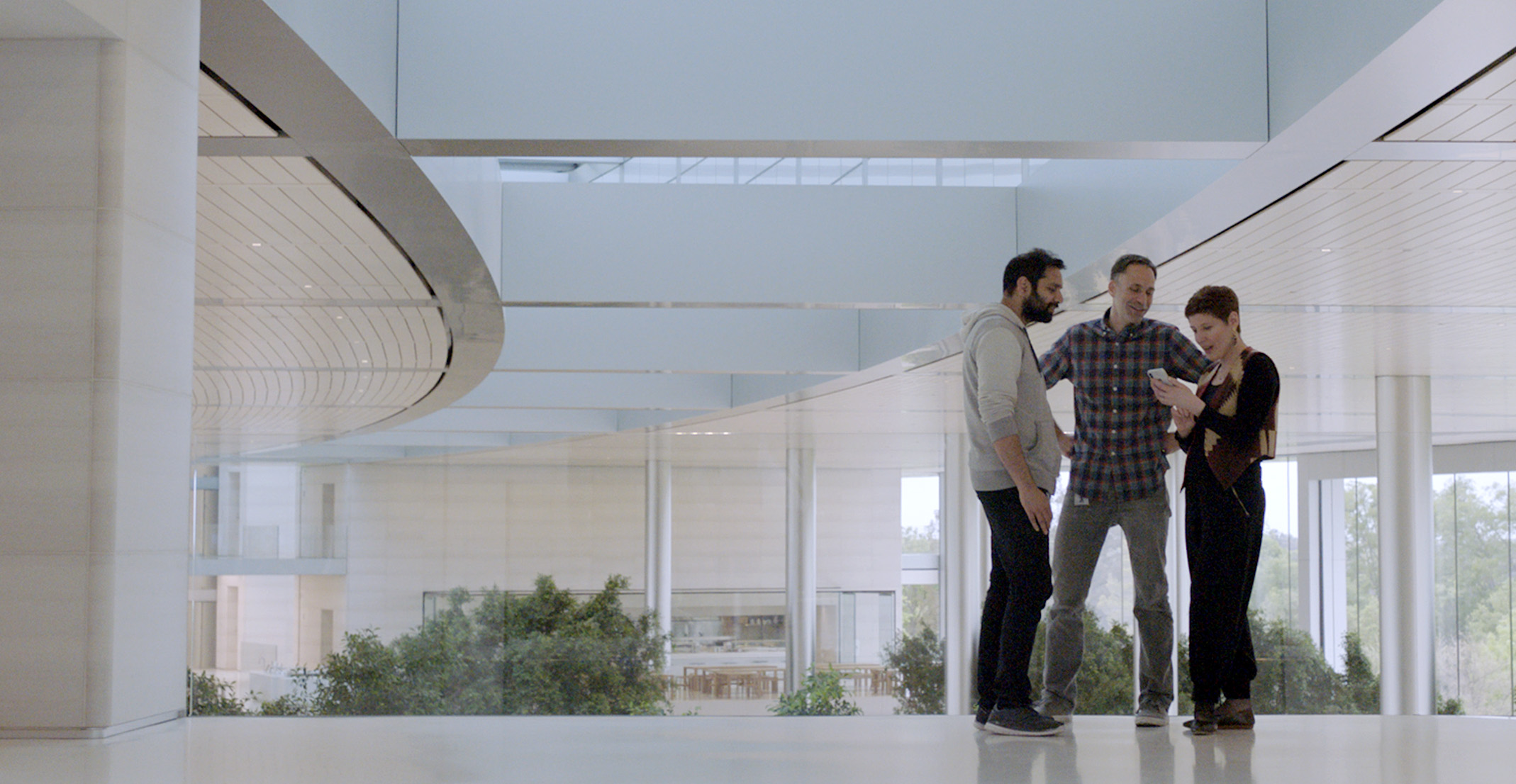 Appleのエンジニアリングマネージャーのセシルがオフィスで同僚と話している。