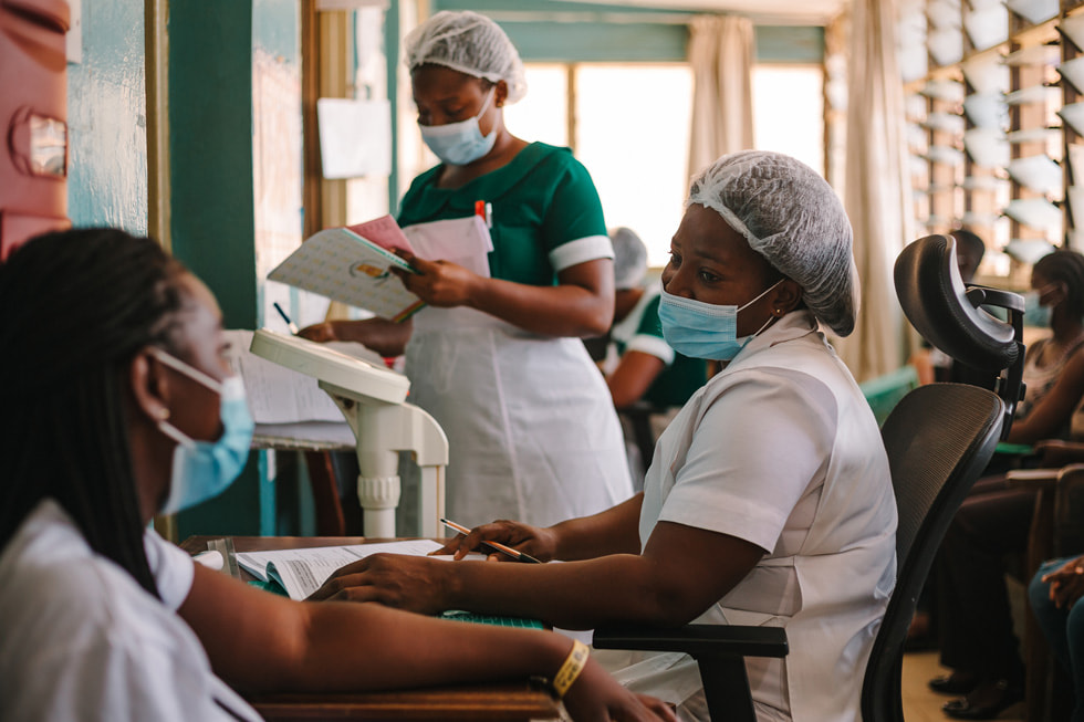 Медсёстры общаются с пациентом в клинике в рамках программы Глобального фонда, направленной на борьбу с COVID-19.